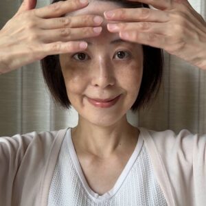 50代_顔のマッサージをする女性