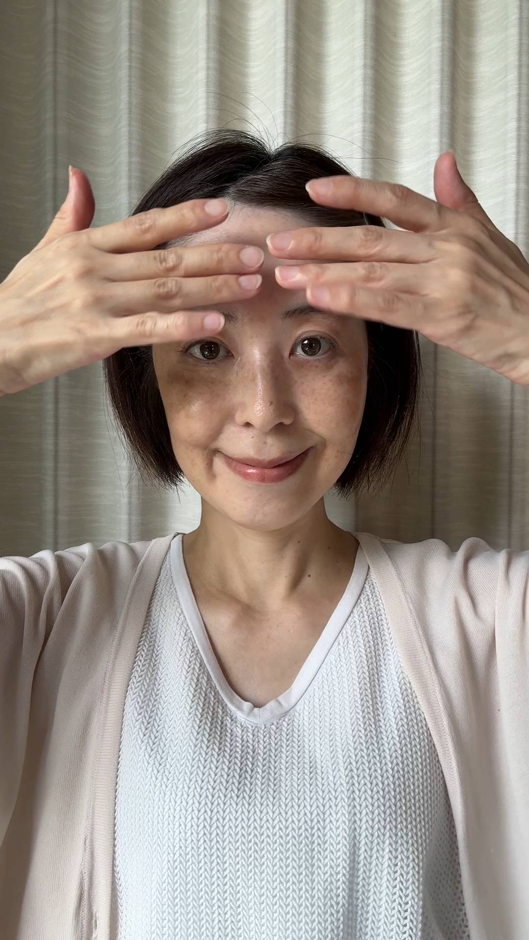 50代_顔のマッサージをする女性