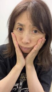 50代_顔のたるみを触る女性