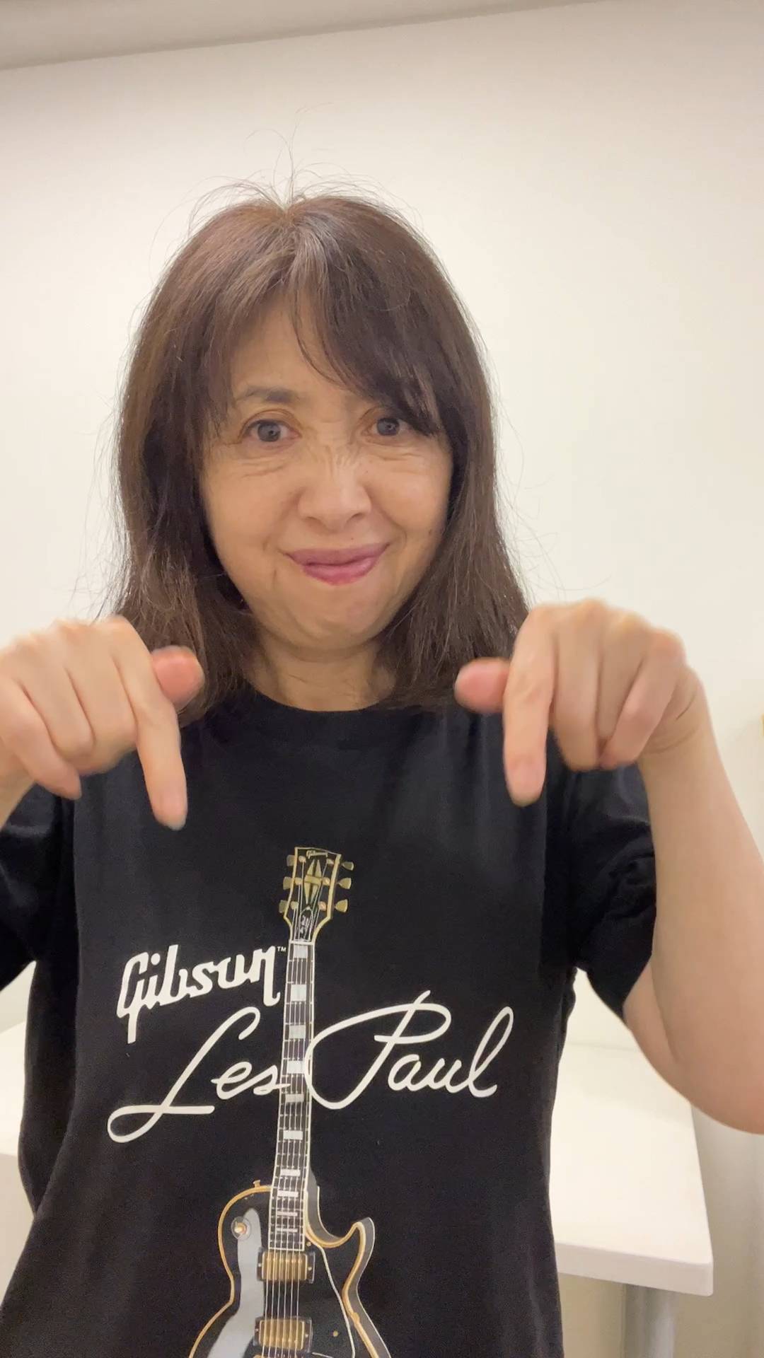 50代_下を指さす女性