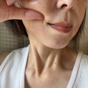 40代_ほっぺをつまむ女性