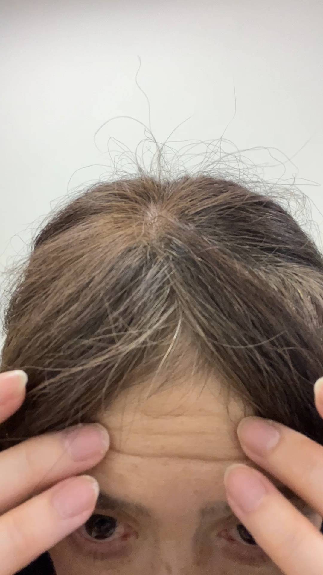 50代_おでこのシワを触る女性