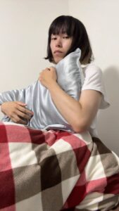 枕を抱え込む女性