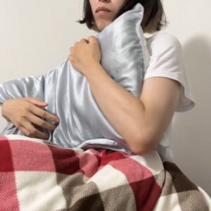 枕を抱え込む女性