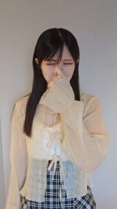 鼻をつまんで臭そうにする女性