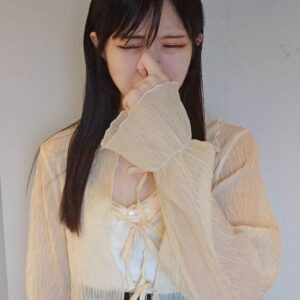 鼻をつまんで臭そうにする女性