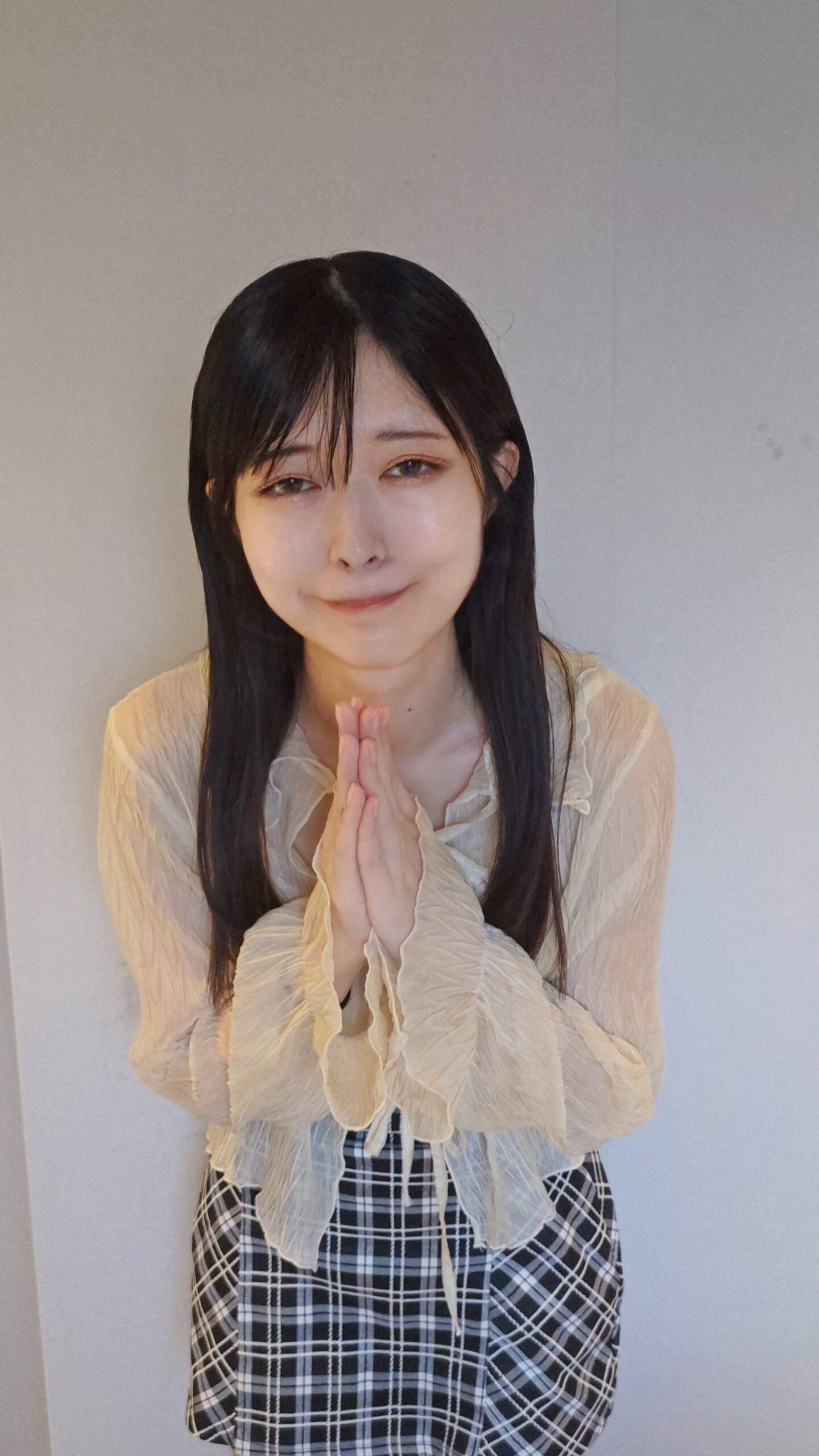 手を合わせてお願いをする女性