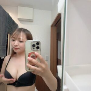 鏡の前でバスト(胸)を持ち上げる女性