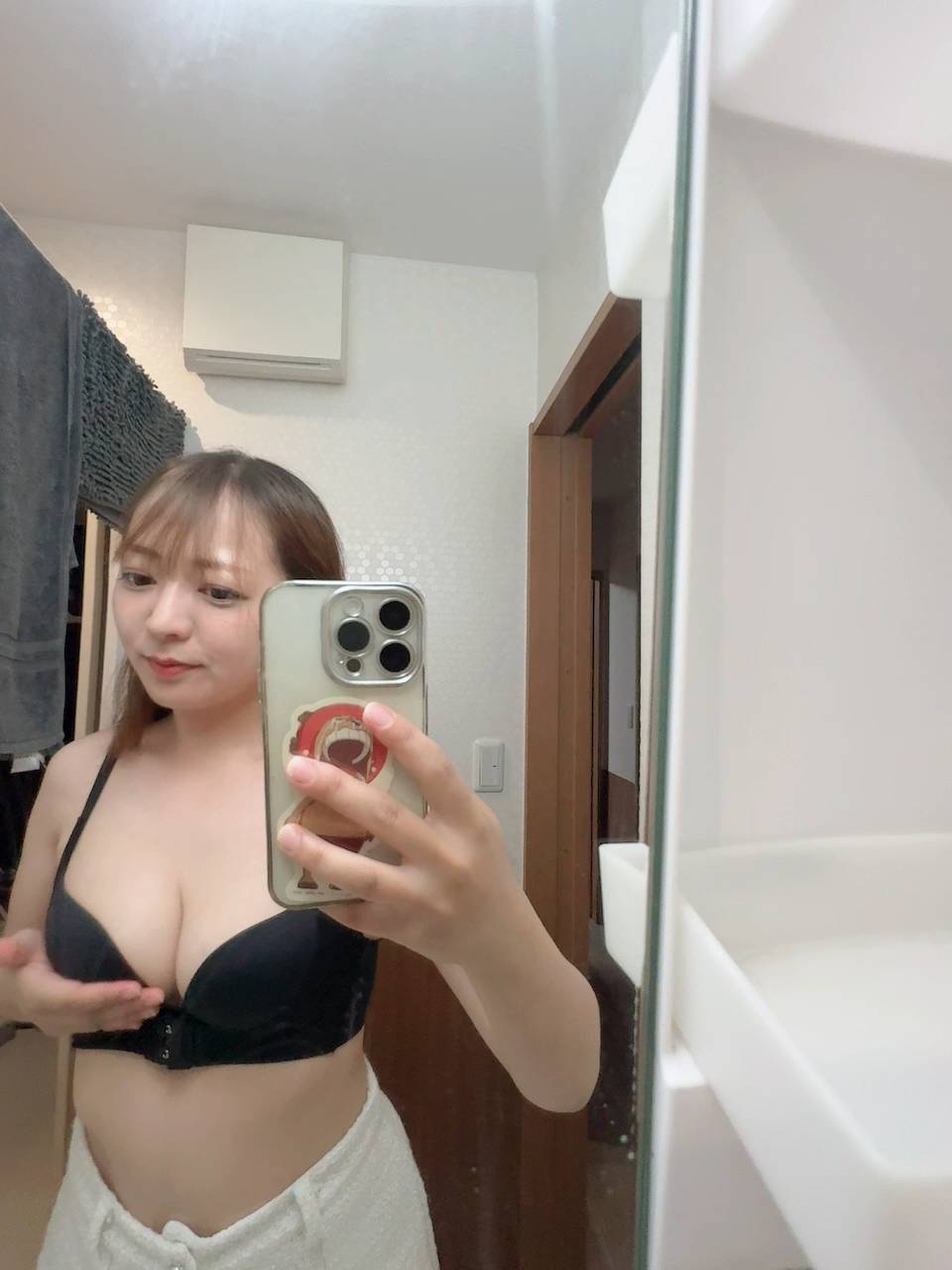 鏡の前でバスト(胸)を持ち上げる女性