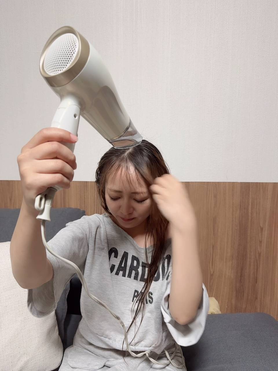 リビングでドライヤーをする女性