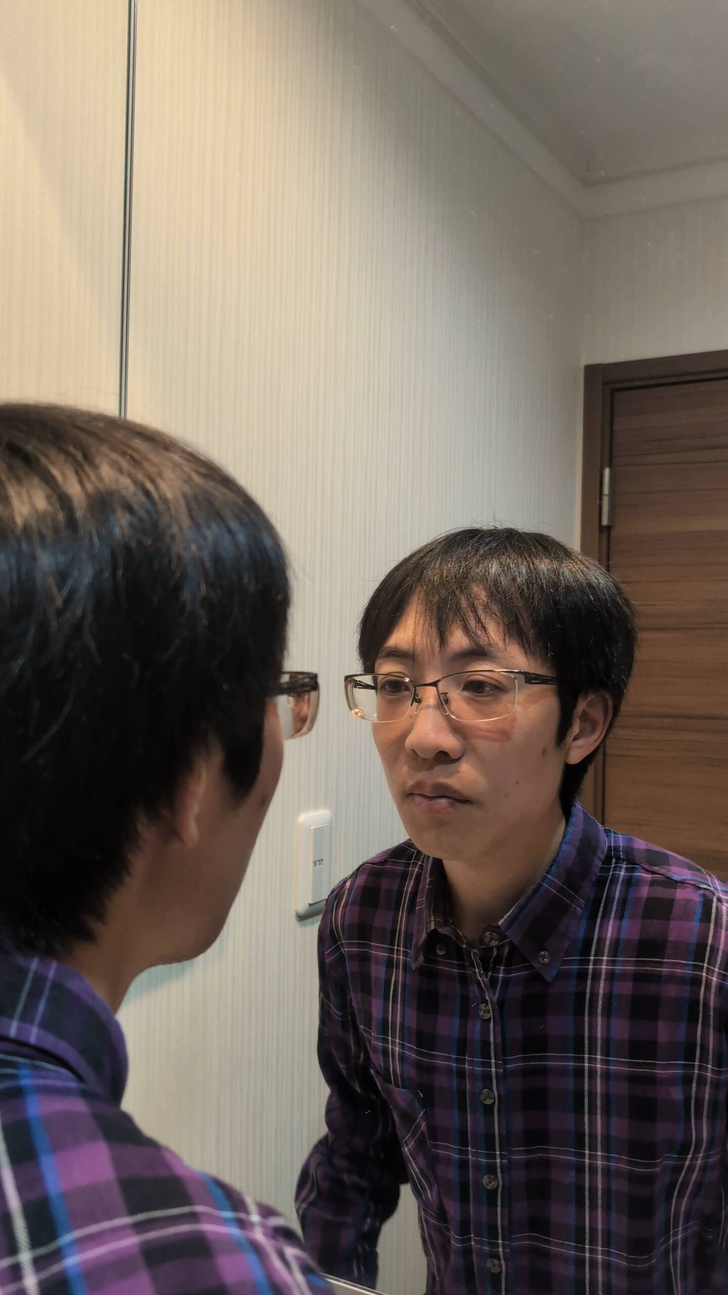 鏡で顔を近づけてチェックする男性｜表情｜ポーズ