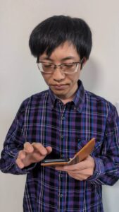 スマホで何かをチェックして満足している男性｜表情｜ポーズ｜投資｜副業