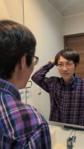 洗面所で髪を触る→自信顔｜AGA｜植毛｜育毛