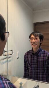 鏡を見て笑って首をかしげる｜AGA｜植毛｜育毛