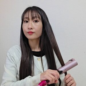 アイロンで髪の毛を巻く女性｜ヘアケア｜美容