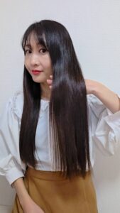 ツヤツヤの髪を自慢する女性｜ヘアケア｜美容