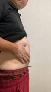 お腹を触る男性｜お腹｜ダイエット
