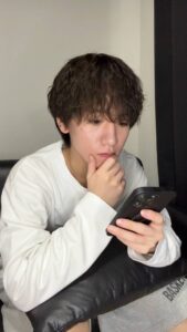 家で携帯をいじる男性｜出会い