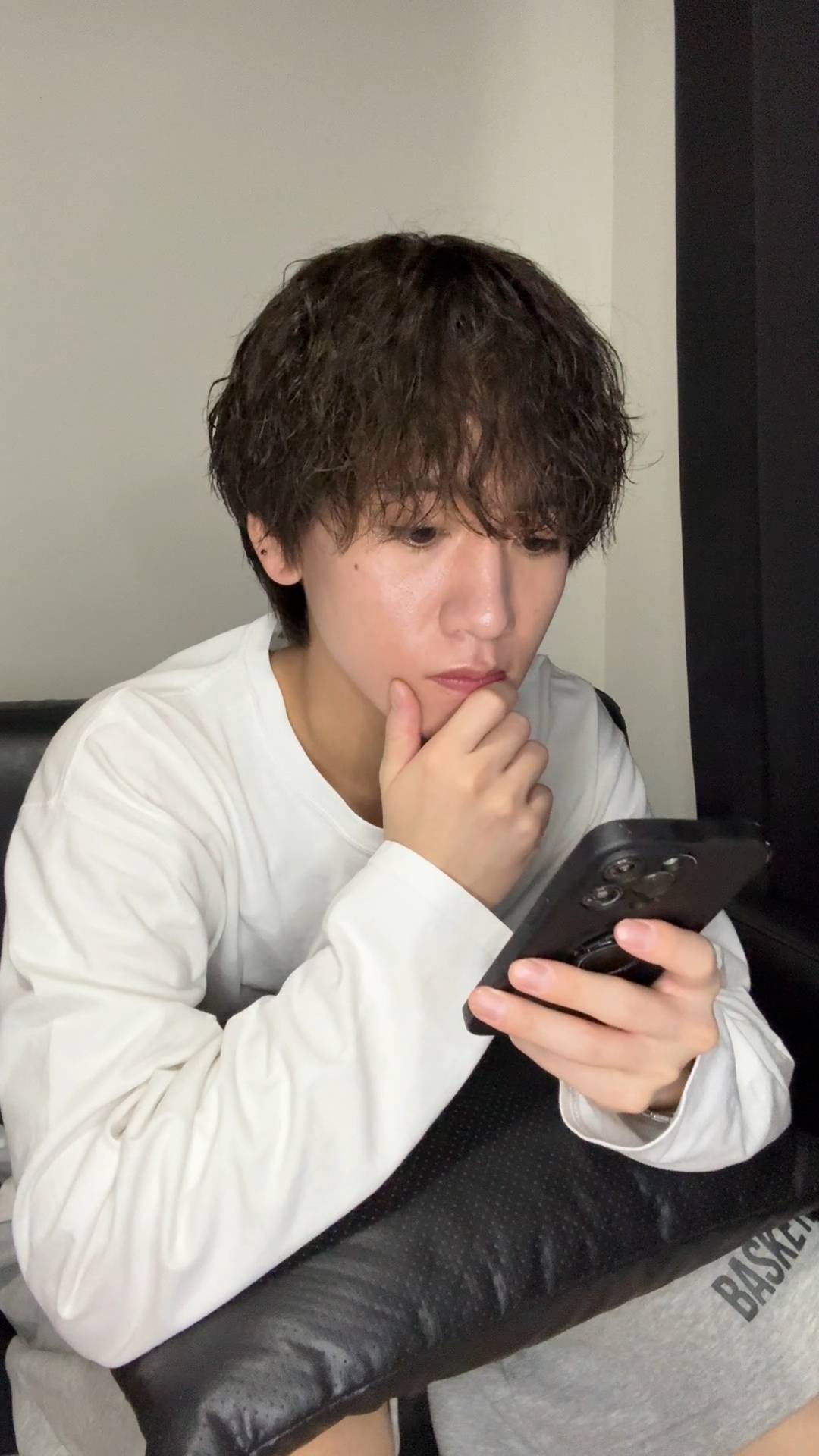 家で携帯をいじる男性｜出会い