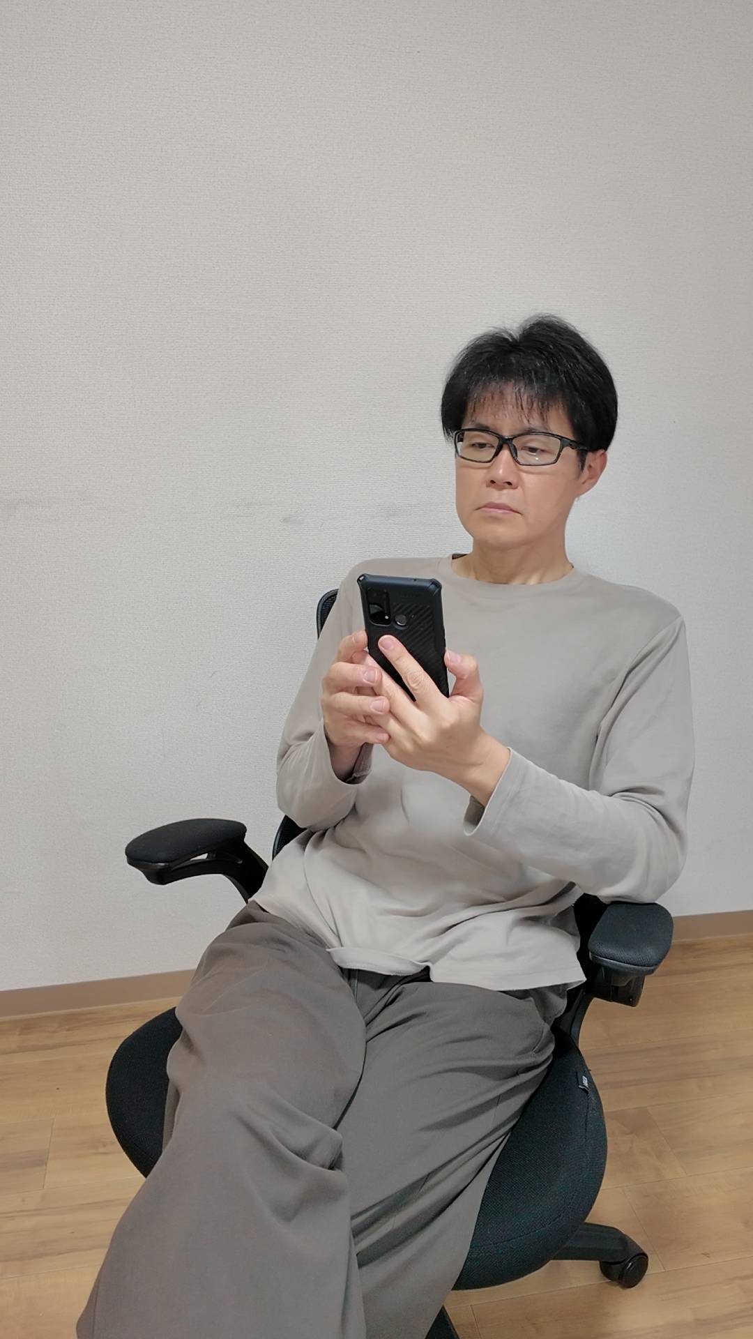 スマホを見て何かを考える男性｜悩み