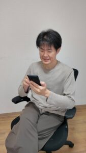 スマホを見て頷く男性｜スマホ｜頷く