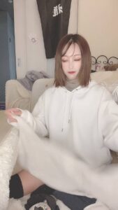 洗濯物を畳みながら微笑む｜日常