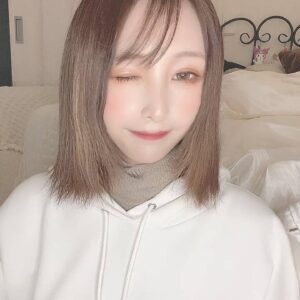 カメラを見てウインクする女性｜笑顔