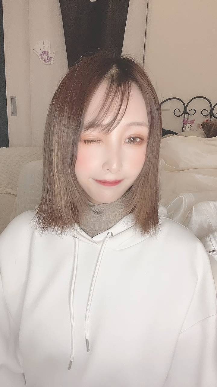 カメラを見てウインクする女性｜笑顔