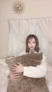 クッションを抱えて笑う女性