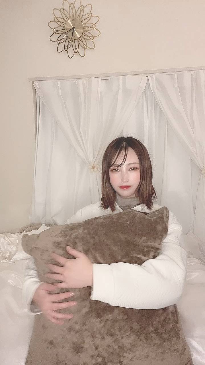 クッションを抱えて笑う女性