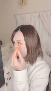 眉毛を整えながら鏡を見て笑う女性｜メイク｜デート｜彼氏目線