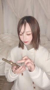 SNS投稿をして笑顔の女性｜スマホ｜SNS