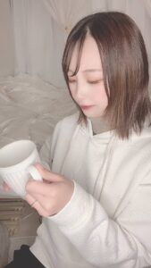 コーヒーカップを持って見つめる女性｜日常
