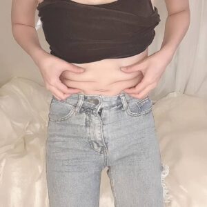 自宅でお腹をつまむ女性｜お腹｜ダイエット