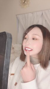 鏡で歯をチェックする女性｜デンタルケア｜ホワイトニング