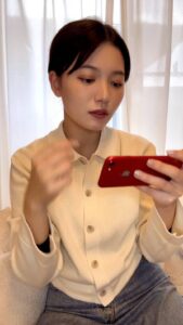 スマホで動画を見て笑う女性｜スマホ｜日常