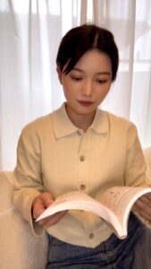 本を読んでうなずく笑顔な女性｜日常