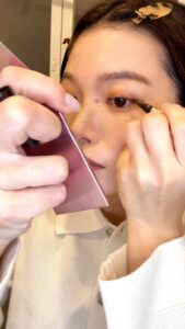 アイラインを引きながら笑顔になる｜メイク｜日常