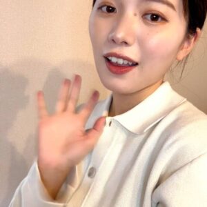 カメラに軽く手を振る女性｜笑顔｜手を振る