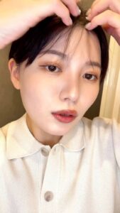 前髪を整える女性｜前髪｜ヘアセット｜笑顔