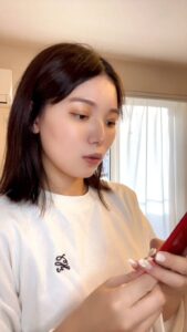 スマホを見て驚き笑顔になる女性｜スマホ｜日常