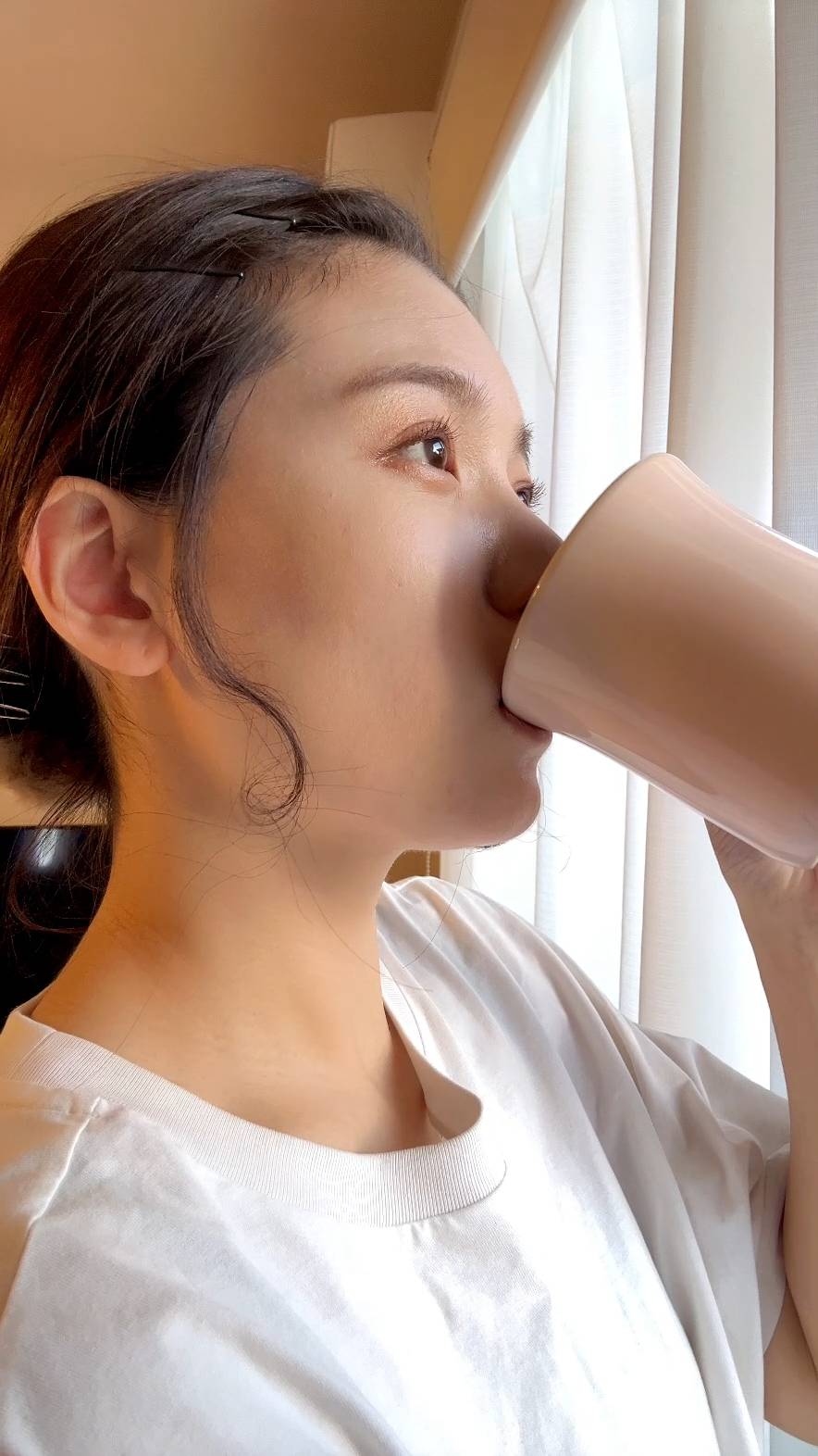 コーヒーを飲みながら目を閉じて満足顔な女性｜笑顔｜コーヒー｜朝日