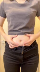 お腹をつまむ女性｜ウエスト｜お腹｜悩み