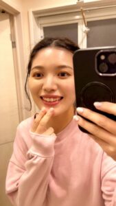 歯をアピールする女性｜鏡越し｜ホワイトニング｜笑顔