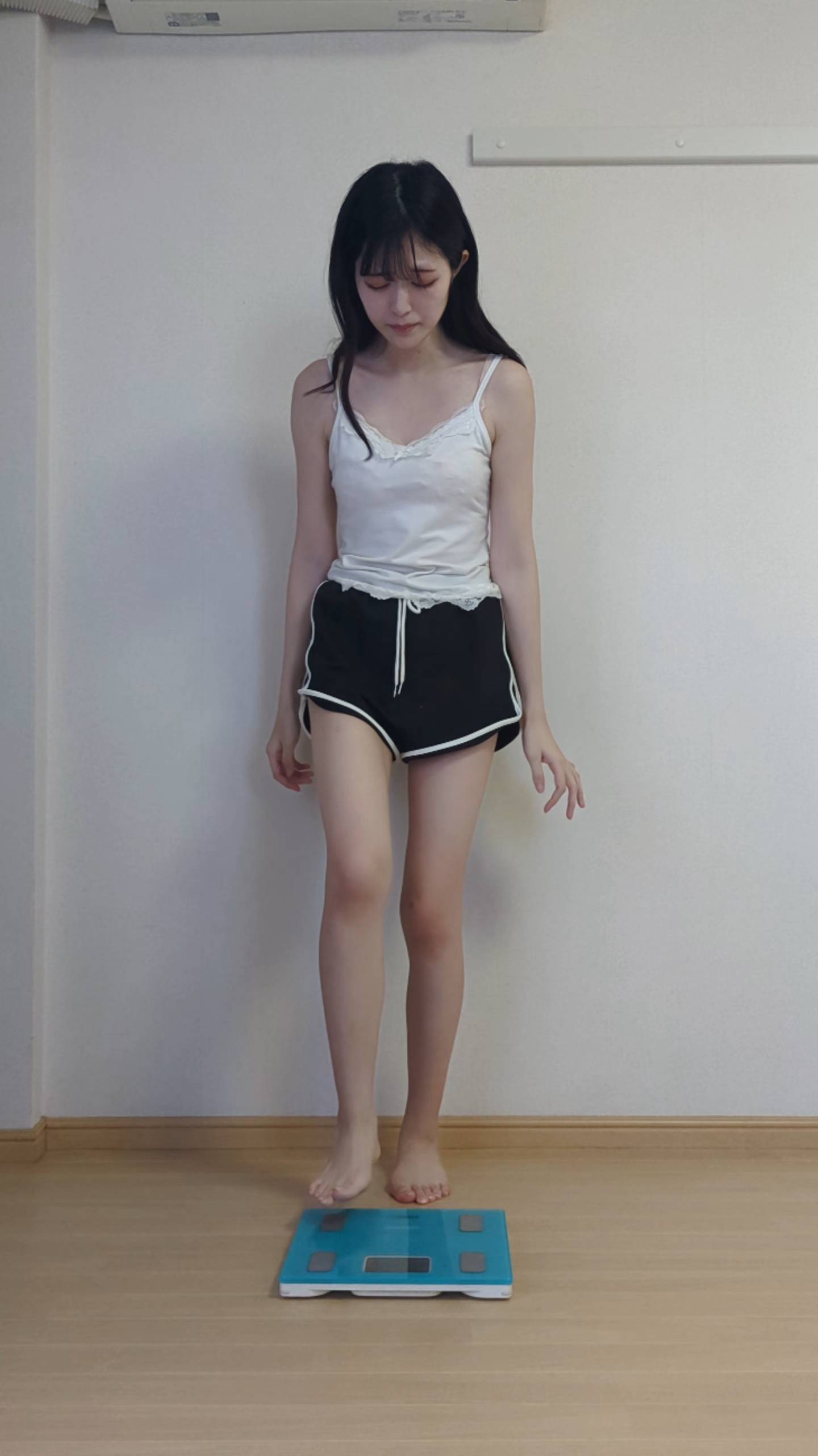 体重計に乗って落ち込む女性