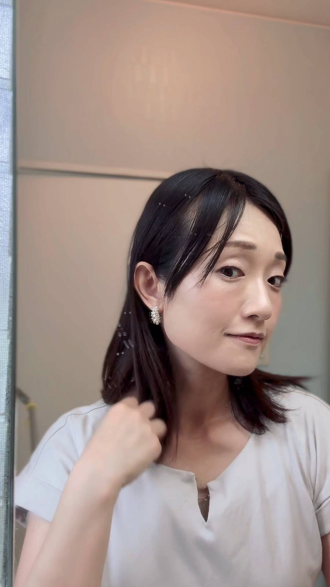 鏡でチェックする女性｜身だしなみ