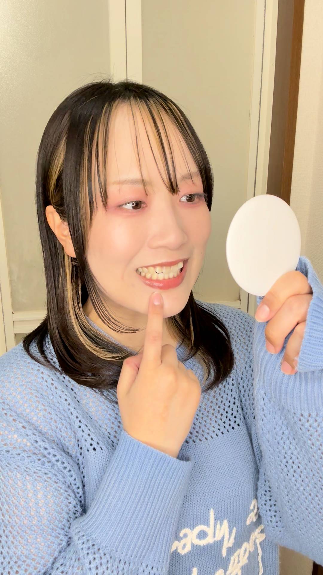 鏡で歯をチェックする女性｜デンタルケア｜ホワイトニング