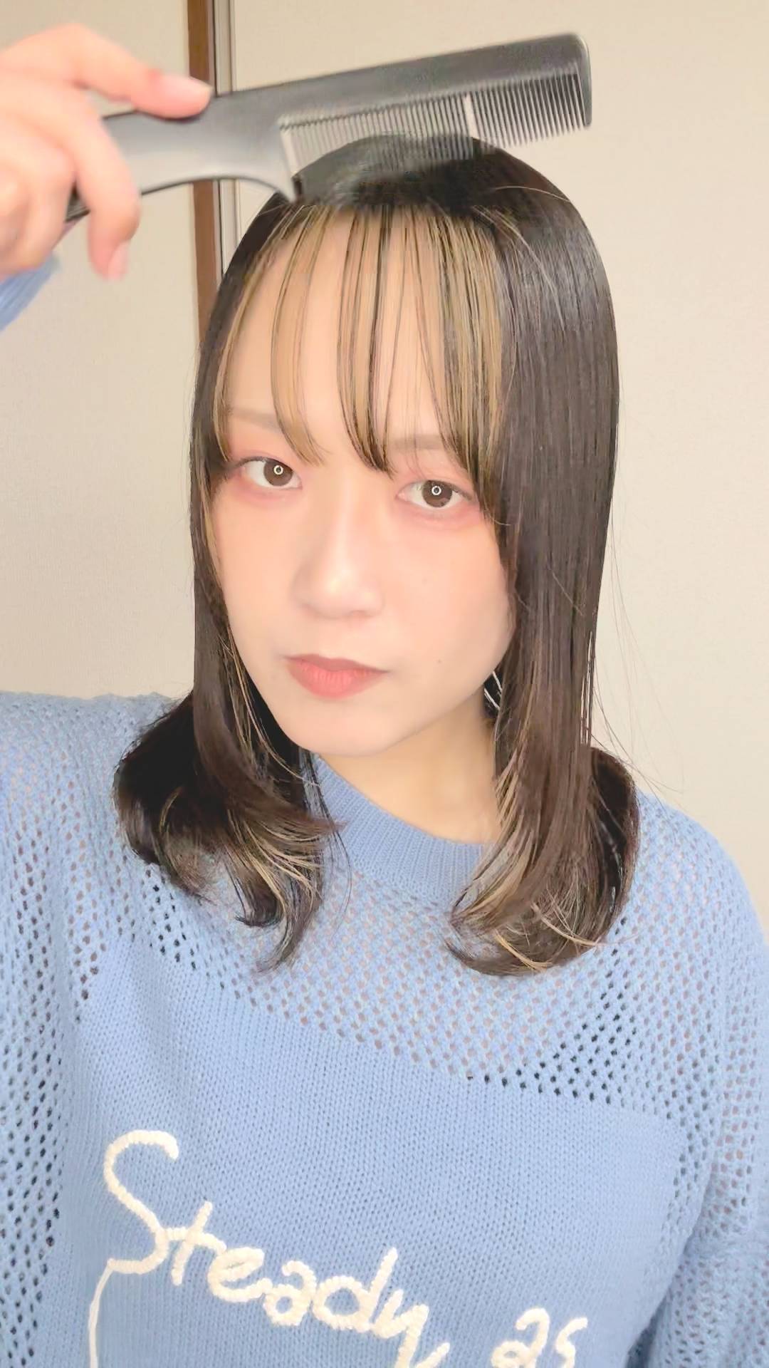 くしで髪をとく女性｜ヘアケア｜日常